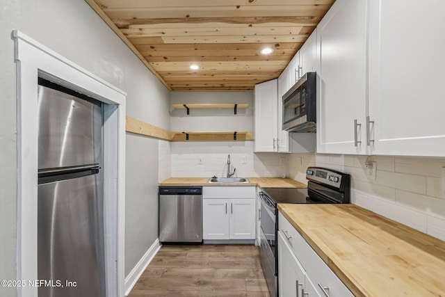 243 Ravenswood Dr, Saint Augustine, FL 32084 - kitchen featuring appliances with stainless steel finishes, wooden counters, light wood-style flooring, white cabinets, and wooden ceiling