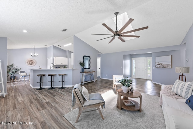 13254 Karla Cove Ln, Jacksonville, FL 32225 - living area with wood finished floors, a chandelier, ceiling fan, a textured ceiling, and high vaulted ceiling