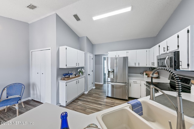 13254 Karla Cove Ln, Jacksonville, FL 32225 - kitchen featuring stainless steel appliances, wood finished floors, white cabinetry, and light countertops