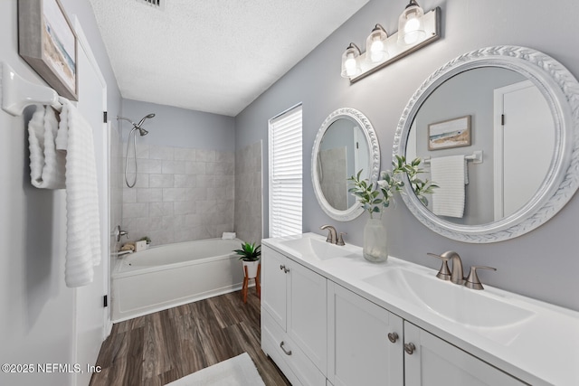 13254 Karla Cove Ln, Jacksonville, FL 32225 - bathroom featuring  shower combination, double vanity, wood finished floors, and a textured ceiling