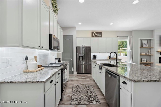 395 Jennie Lake Ct, Saint Johns, FL 32095 - kitchen with appliances with stainless steel finishes, tasteful backsplash, white cabinets, a center island with sink, and recessed lighting