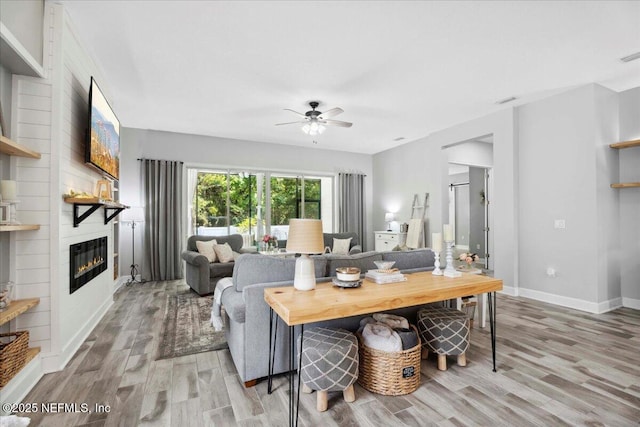 395 Jennie Lake Ct, Saint Johns, FL 32095 - living area with light wood-style floors, a ceiling fan, and a fireplace