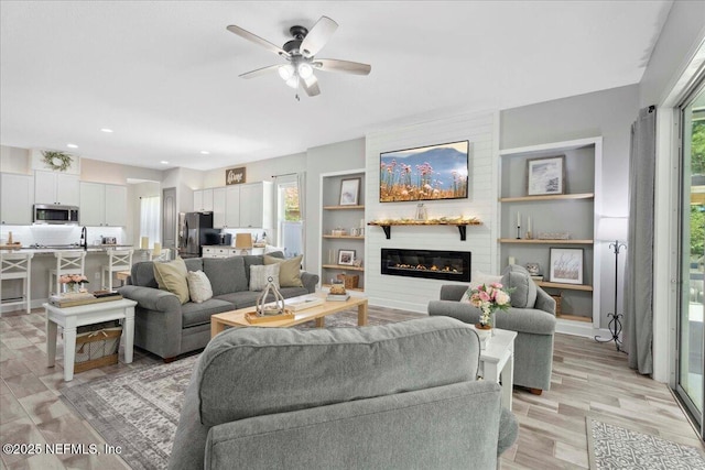 395 Jennie Lake Ct, Saint Johns, FL 32095 - living room featuring healthy amount of natural light, a fireplace, ceiling fan, and light wood-style flooring