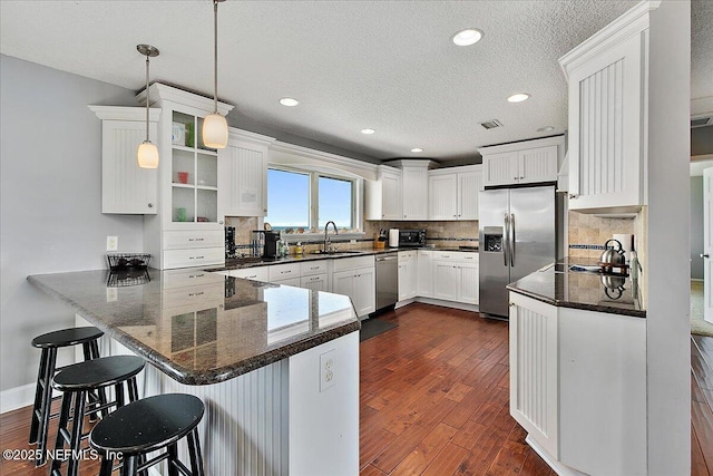 2481 S Ponte Vedra Blvd, Ponte Vedra Beach, FL 32082 - kitchen featuring stainless steel appliances, a peninsula, dark wood-type flooring, tasteful backsplash, and white cabinetry