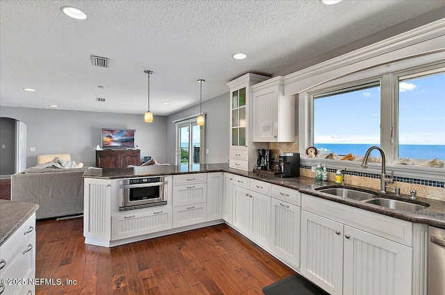 2481 S Ponte Vedra Blvd, Ponte Vedra Beach, FL 32082 - kitchen with a peninsula, open floor plan, glass insert cabinets, white cabinets, and dark wood-type flooring
