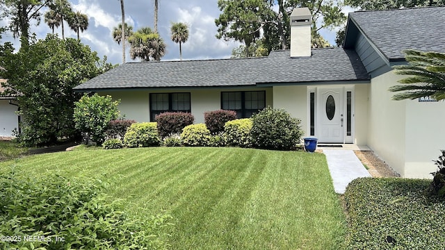 110 Abalone Ln W, Ponte Vedra Beach, FL 32082 - view of front of house featuring roof with shingles, stucco siding, a front yard, and a chimney