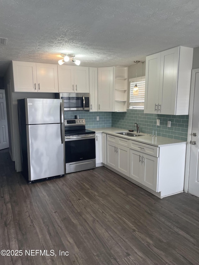 130 Gassett Rd, Saint Augustine, FL 32080 - kitchen with appliances with stainless steel finishes, white cabinetry, dark wood-type flooring, light countertops, and a textured ceiling