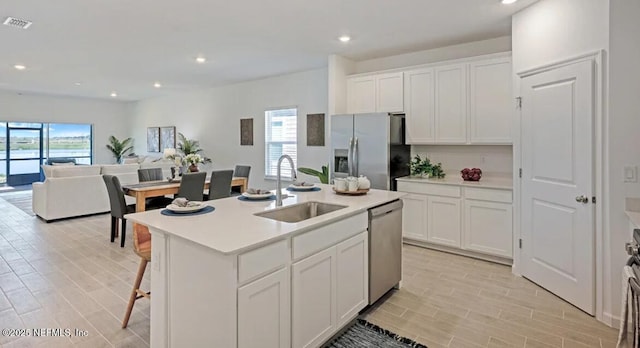 179 Charmer Trce, Saint Augustine, FL 32092 - kitchen featuring stainless steel appliances, white cabinets, open floor plan, light wood finished floors, and light countertops