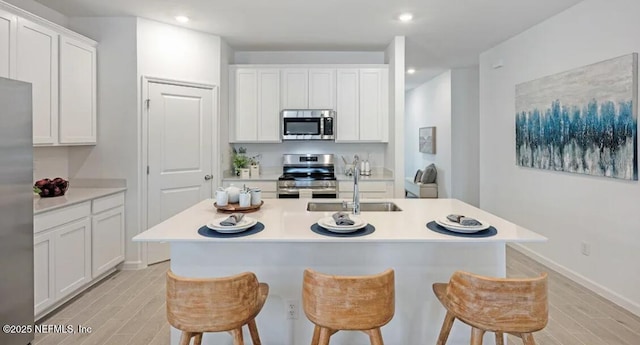 179 Charmer Trce, Saint Augustine, FL 32092 - kitchen featuring appliances with stainless steel finishes, light wood-type flooring, a kitchen bar, and recessed lighting