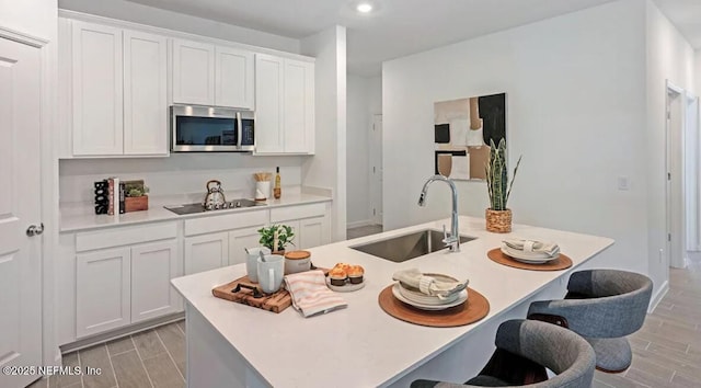 179 Charmer Trce, Saint Augustine, FL 32092 - kitchen with stainless steel microwave, black electric cooktop, wood finish floors, white cabinets, and recessed lighting