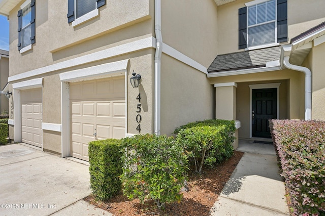 1500 Calming Water Dr Unit 4504, Fleming Island, FL 32003 - entrance to property with a garage, stucco siding, concrete driveway, and a shingled roof