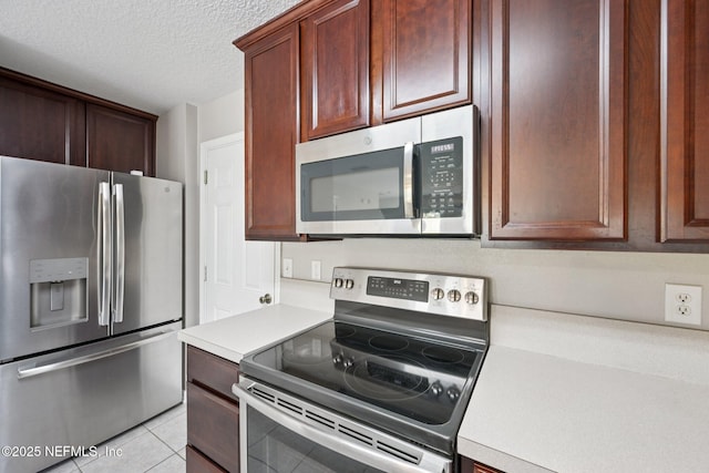 1500 Calming Water Dr Unit 4504, Fleming Island, FL 32003 - kitchen featuring appliances with stainless steel finishes, light countertops, a textured ceiling, and light tile patterned floors