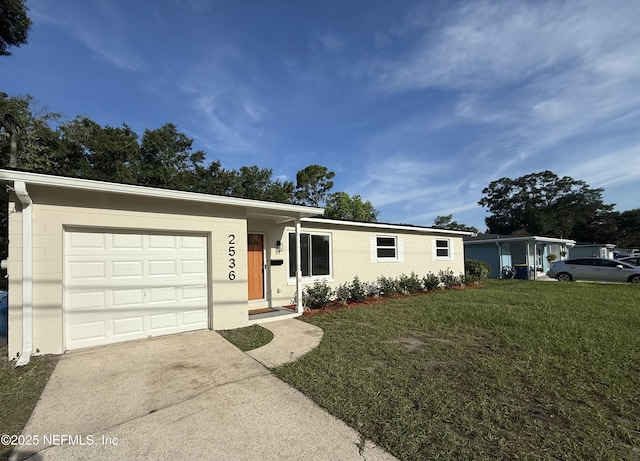 2536 Wedgefield Blvd, Jacksonville, FL 32211 - ranch-style house with concrete block siding, driveway, a front yard, and an attached garage