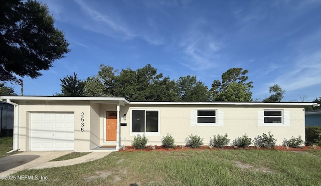 2536 Wedgefield Blvd, Jacksonville, FL 32211 - ranch-style home featuring concrete block siding, a front yard, an attached garage, and driveway
