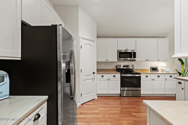 96220 Ridgewood Cir, Fernandina Beach, FL 32034 - kitchen with appliances with stainless steel finishes, light countertops, and white cabinetry