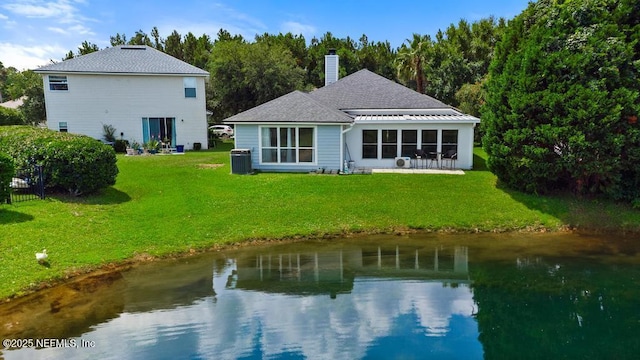 96220 Ridgewood Cir, Fernandina Beach, FL 32034 - rear view of house featuring a chimney, a yard, and a water view