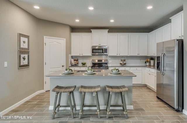 2621 Lavender Loop, Green Cove Springs, FL 32043 - kitchen featuring stainless steel appliances, backsplash, a breakfast bar, white cabinetry, and recessed lighting