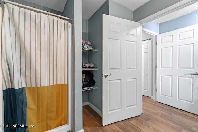 113 Oceangate Dr, Atlantic Beach, FL 32233 - bathroom with wood finished floors and a shower with shower curtain