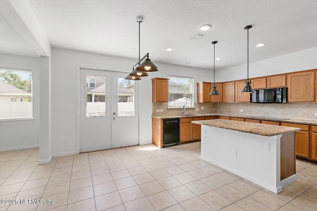 1415 Lantern Light Trl, Middleburg, FL 32068 - kitchen with black appliances, backsplash, a kitchen island, a textured ceiling, and light stone counters