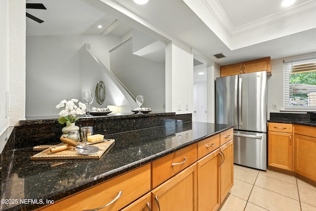736 Tidewater Ct, Ponte Vedra Beach, FL 32082 - kitchen featuring freestanding refrigerator, dark stone countertops, light tile patterned floors, brown cabinetry, and ornamental molding