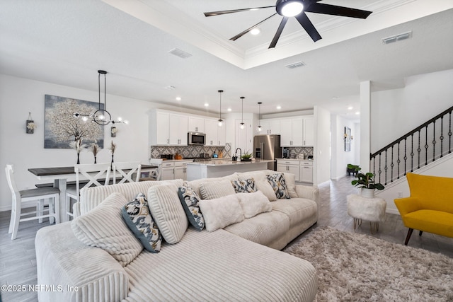 816 Blind Oak Way, Middleburg, FL 32068 - living area with light wood finished floors, ornamental molding, a tray ceiling, recessed lighting, and a ceiling fan