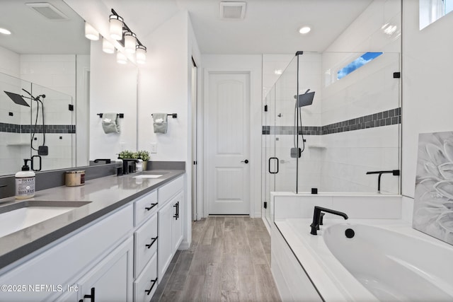 816 Blind Oak Way, Middleburg, FL 32068 - bathroom with a garden tub, a stall shower, double vanity, wood finished floors, and healthy amount of natural light