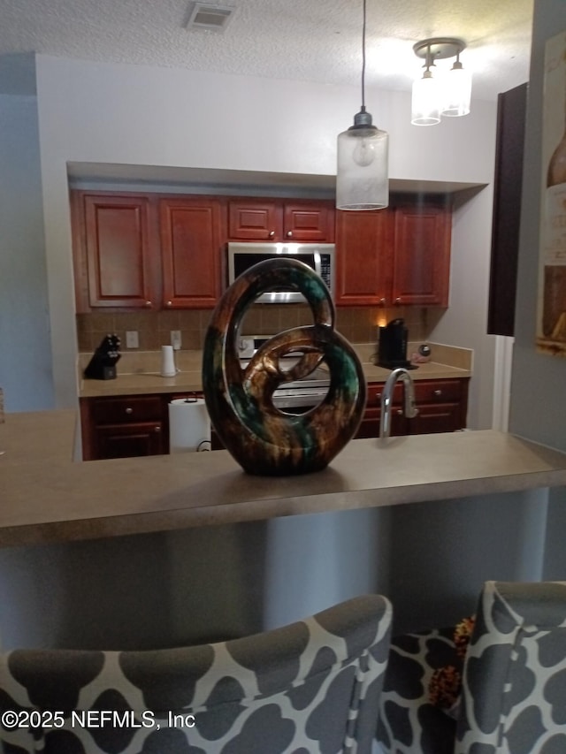 3671 Kirkpatrick Cir Unit 6, Jacksonville, FL 32210 - detailed view of stainless steel microwave, decorative backsplash, a textured ceiling, and light countertops