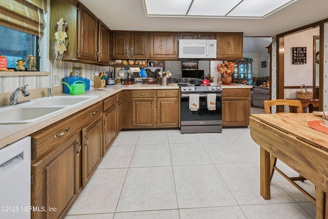 4253 Chokeberry Rd, Middleburg, FL 32068 - kitchen featuring white appliances, light countertops, light tile patterned floors, and brown cabinetry