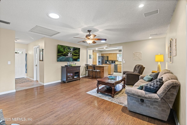 4115 Wilcrest Cir W, Jacksonville, FL 32277 - living area with light wood-style floors, a textured ceiling, a ceiling fan, and recessed lighting