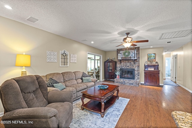 4115 Wilcrest Cir W, Jacksonville, FL 32277 - living area with ceiling fan, wood finished floors, a textured ceiling, a brick fireplace, and recessed lighting
