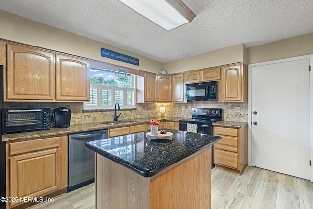 4115 Wilcrest Cir W, Jacksonville, FL 32277 - kitchen featuring black appliances, dark stone counters, light wood-type flooring, a textured ceiling, and backsplash