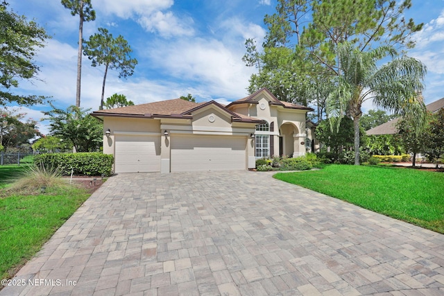 1506 Waterbridge Ct, Fleming Island, FL 32003 - mediterranean / spanish house with decorative driveway, stucco siding, a front lawn, and a garage