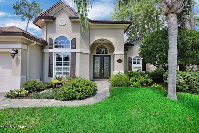 1506 Waterbridge Ct, Fleming Island, FL 32003 - view of front of property featuring french doors, stucco siding, a front lawn, and an attached garage