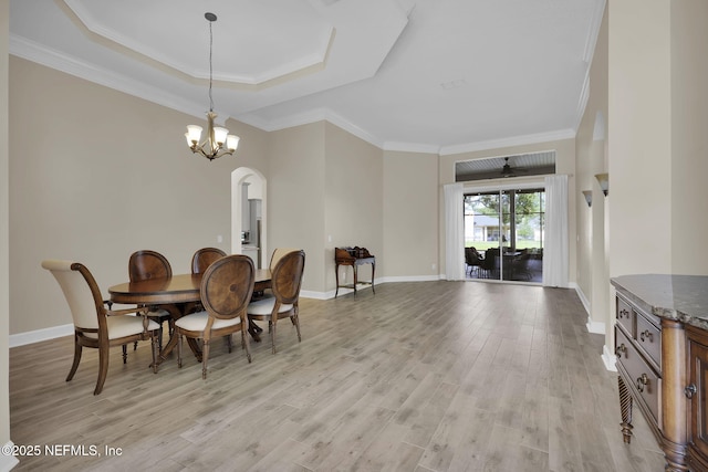 1506 Waterbridge Ct, Fleming Island, FL 32003 - dining area with arched walkways, light wood-type flooring, ornamental molding, a chandelier, and a raised ceiling
