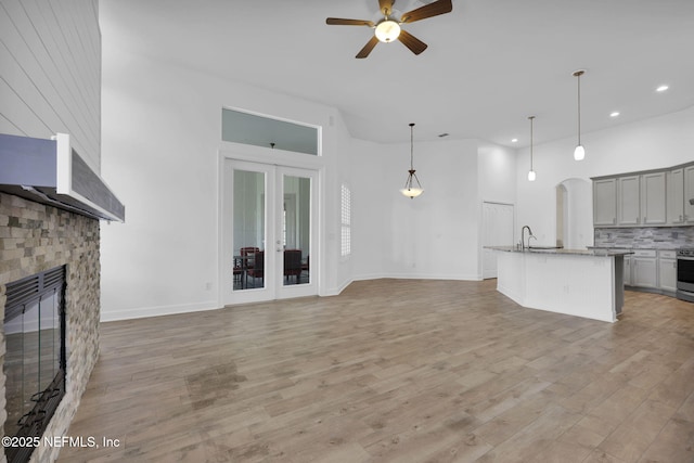 1506 Waterbridge Ct, Fleming Island, FL 32003 - unfurnished living room featuring ceiling fan, a large fireplace, recessed lighting, light wood-style floors, and french doors