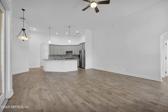 1506 Waterbridge Ct, Fleming Island, FL 32003 - unfurnished living room featuring arched walkways, ceiling fan, recessed lighting, and wood finished floors