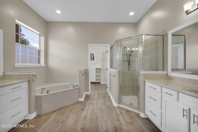 1506 Waterbridge Ct, Fleming Island, FL 32003 - bathroom featuring a shower stall, vanity, wood finished floors, a bath, and a spacious closet