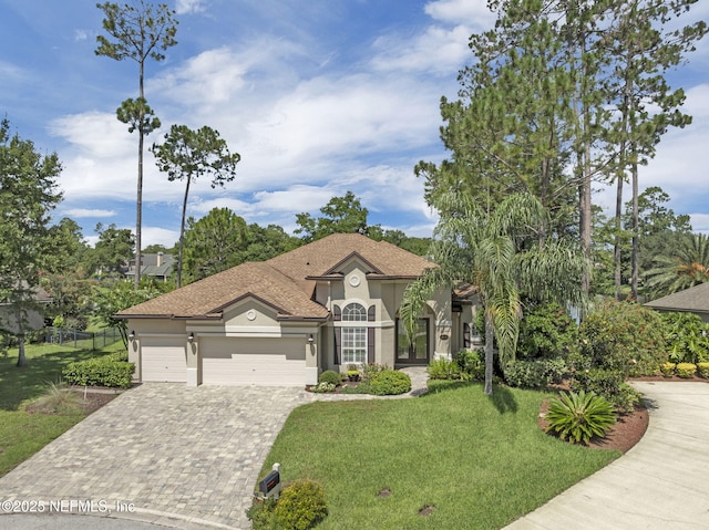 1506 Waterbridge Ct, Fleming Island, FL 32003 - mediterranean / spanish home with stucco siding, decorative driveway, a front yard, a garage, and french doors