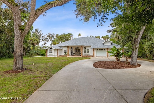 1465 Lambert Ave, Flagler Beach, FL 32136 - view of front facade featuring curved driveway, an attached garage, brick siding, a front lawn, and a shingled roof