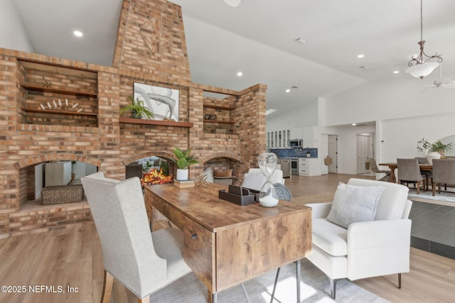 1465 Lambert Ave, Flagler Beach, FL 32136 - living area with a fireplace, high vaulted ceiling, wood finished floors, and a chandelier