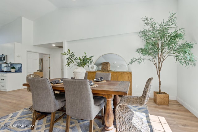 1465 Lambert Ave, Flagler Beach, FL 32136 - dining space with light wood-style flooring and high vaulted ceiling