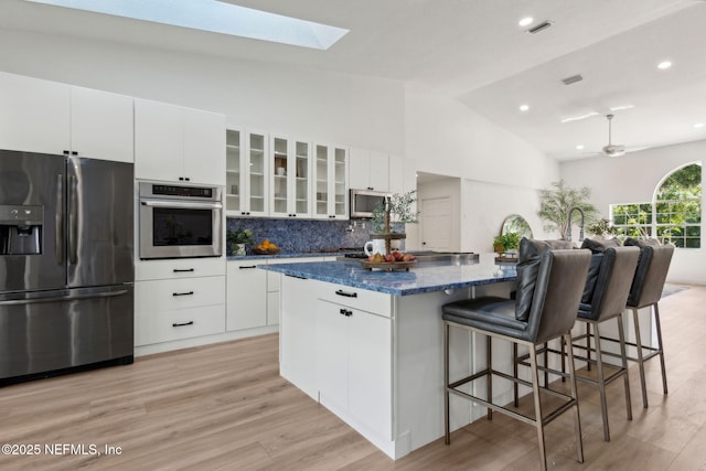 1465 Lambert Ave, Flagler Beach, FL 32136 - kitchen with appliances with stainless steel finishes, a spacious island, a skylight, a ceiling fan, and white cabinetry