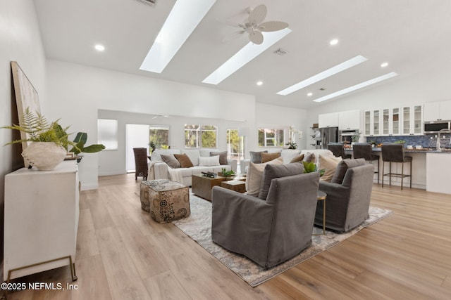 1465 Lambert Ave, Flagler Beach, FL 32136 - living room featuring a skylight, light wood-style floors, recessed lighting, high vaulted ceiling, and a ceiling fan
