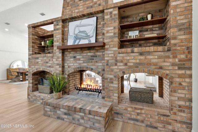 1465 Lambert Ave, Flagler Beach, FL 32136 - living area featuring wood finished floors, arched walkways, and a brick fireplace