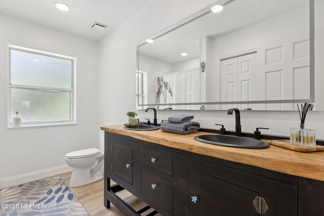 1465 Lambert Ave, Flagler Beach, FL 32136 - full bathroom with double vanity, wood finished floors, a shower with curtain, and recessed lighting