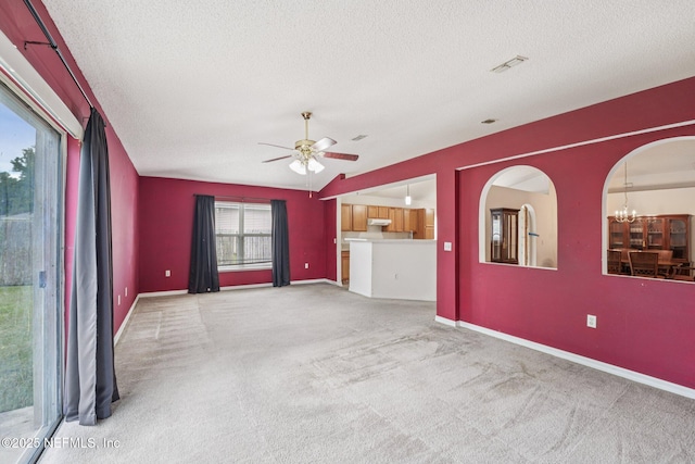 3005 Sunset Ridge Dr, Middleburg, FL 32068 - unfurnished living room featuring a textured ceiling, carpet, a ceiling fan, arched walkways, and a chandelier