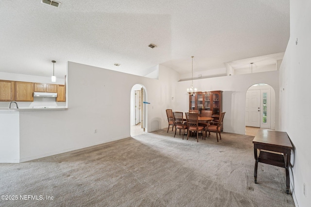 3005 Sunset Ridge Dr, Middleburg, FL 32068 - dining room with arched walkways, vaulted ceiling, light carpet, a textured ceiling, and a chandelier
