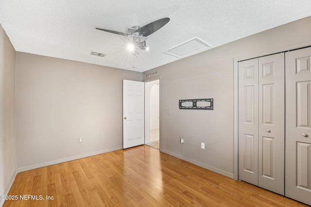3005 Sunset Ridge Dr, Middleburg, FL 32068 - unfurnished bedroom with light wood-style floors, a textured ceiling, a closet, attic access, and ceiling fan