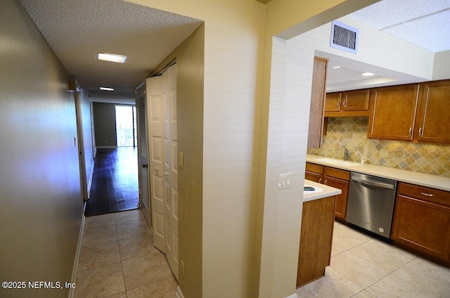 1810 Sevilla Blvd Unit 202, Atlantic Beach, FL 32233 - kitchen featuring dishwasher, light countertops, light tile patterned floors, and a textured ceiling
