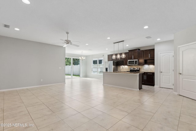 94032 Woodbrier Cir, Fernandina Beach, FL 32034 - kitchen featuring appliances with stainless steel finishes, open floor plan, decorative backsplash, light tile patterned floors, and recessed lighting
